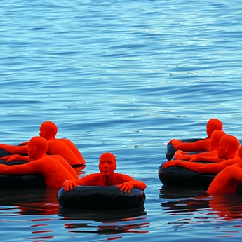 Red People Floating on Inner Tubes Photograph