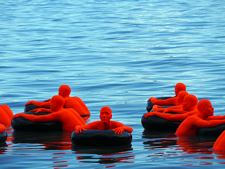 Red People Floating on Inner Tubes Photograph